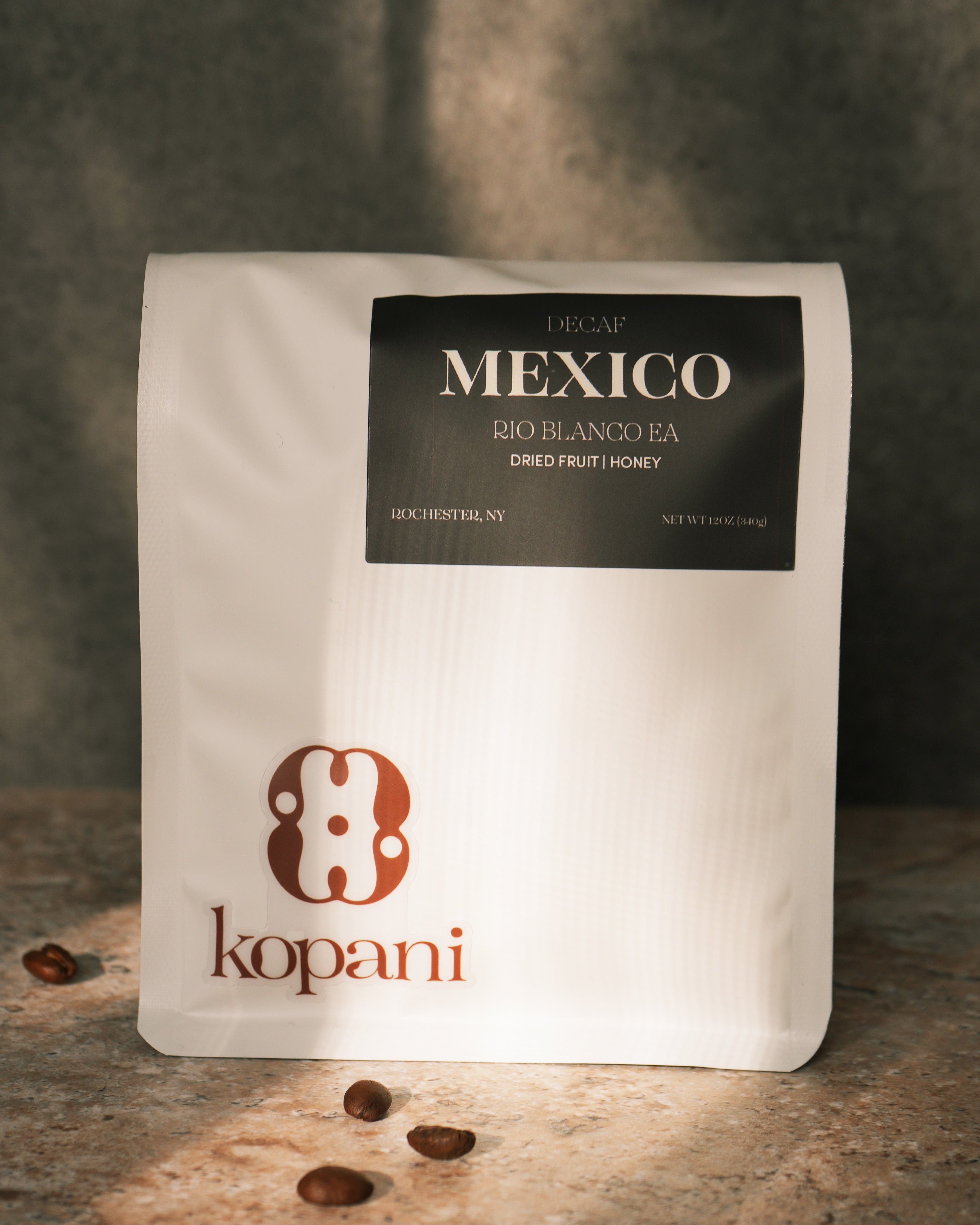 Kopani coffee bag with coffee beans on a textured surface
